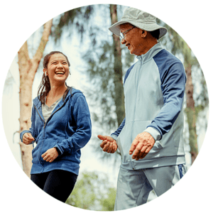 Young adult woman and older adult man walking in part