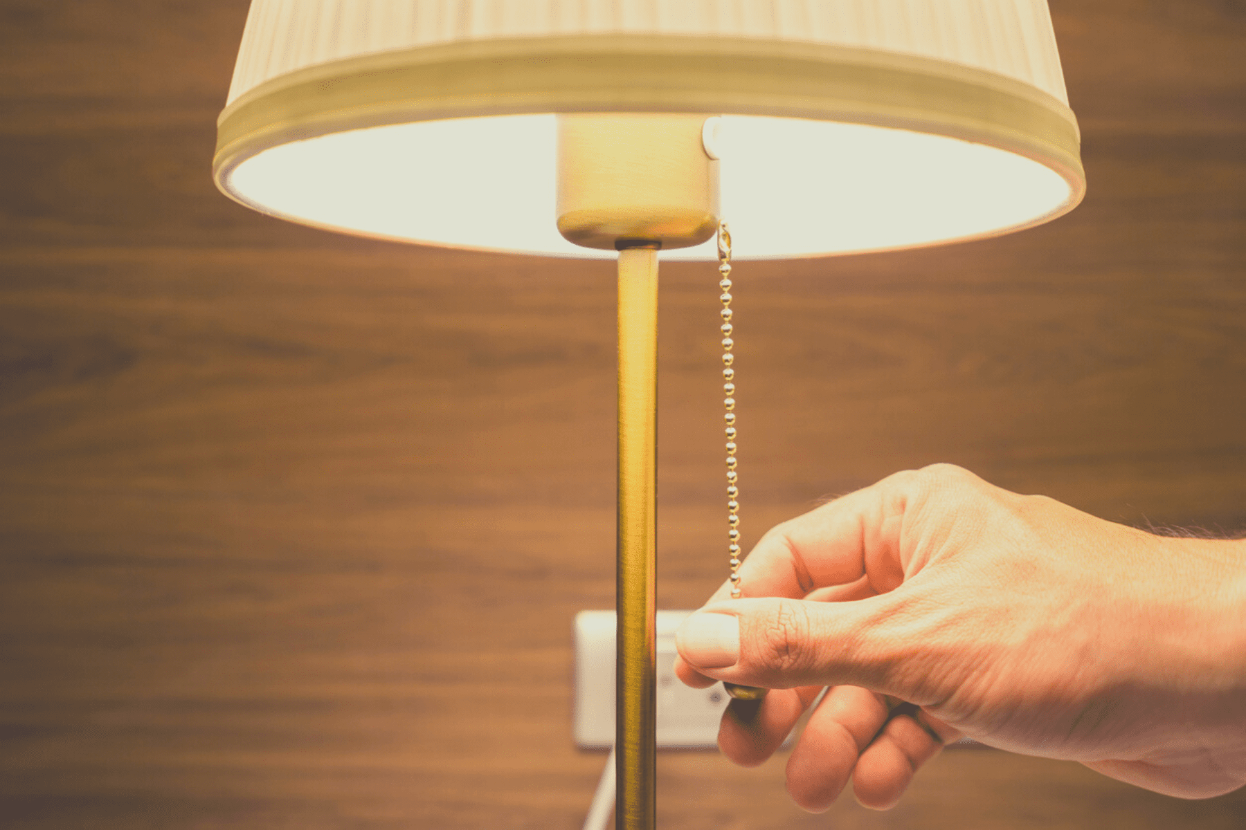 Close up of hand pulling sting to turn on a lamp