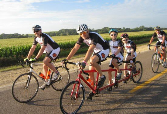 Jay Alberts riding a tandem bike with two kids behind him at RAGBRAI - Davis Phinney Foundation