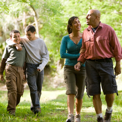 Family of four people walking in park